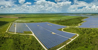 Temiz elektrik enerjisi üretmek için sıra sıra güneş fotovoltaik panelleri olan sürdürülebilir büyük elektrik santralinin havadan görünüşü. Sıfır emisyonlu yenilenebilir elektrik kavramı.