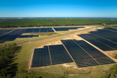 Temiz elektrik enerjisi üretmek için sıra sıra güneş fotovoltaik panelleri olan sürdürülebilir büyük elektrik santralinin havadan görünüşü. Sıfır emisyonlu yenilenebilir elektrik kavramı.