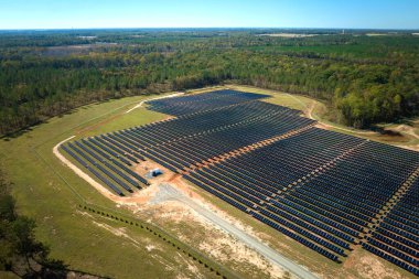 Temiz elektrik enerjisi üretmek için sıra sıra güneş fotovoltaik panelleri olan sürdürülebilir büyük elektrik santralinin havadan görünüşü. Sıfır emisyonlu yenilenebilir elektrik kavramı.