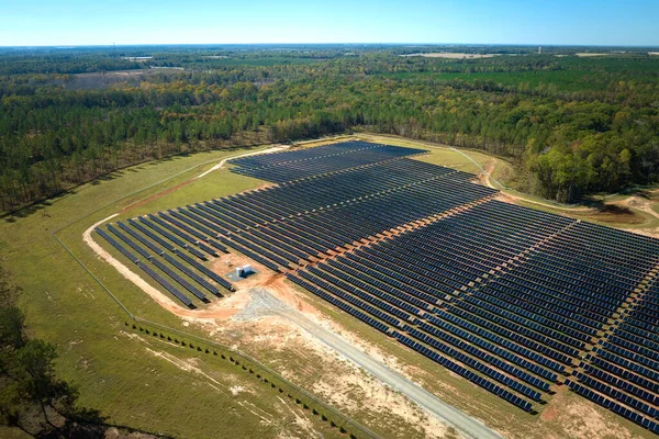 Temiz elektrik enerjisi üretmek için sıra sıra güneş fotovoltaik panelleri olan sürdürülebilir büyük elektrik santralinin havadan görünüşü. Sıfır emisyonlu yenilenebilir elektrik kavramı.