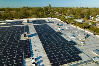 Fotovoltaik güneş panelleri yeşil ekolojik elektrik üretmek için sanayi binasının çatısına monte edildi. Sürdürülebilir enerji konsepti üretimi.
