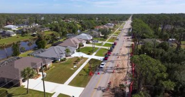 Ekipler yol kenarındaki atık su boruları için hendek kazarken tek şeritli trafik Florida mahalle caddesinde akıyor.