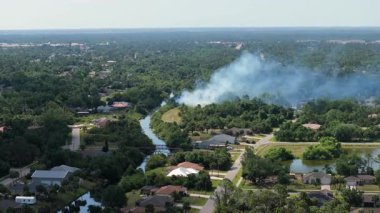 Florida ormanlarında evlere bitişik bitkisel yangın. Mahalle sakinleri bölgeyi boşaltıyor ve çevreyi kirleten hava kirletiyor..