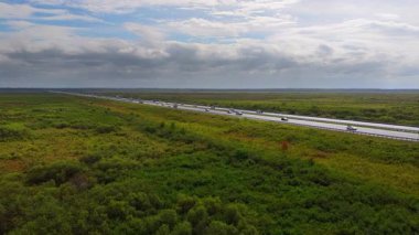 Florida 'da I-75 karayolunun düz bir uzantısı. Açık ve güneşli bir günde, sabit araç trafiğiyle sulak alanlardan geçiyor.