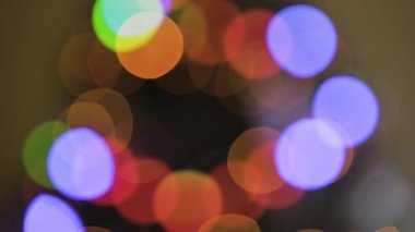 Altın ve kırmızı Noel ışıklarından oluşan yumuşak, ışıldayan bokeh sıcak, neşeli bir zemin oluşturuyor.