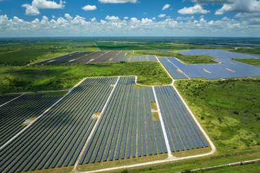 Temiz elektrik enerjisi üretmek için sıra sıra güneş fotovoltaik panelleri olan sürdürülebilir büyük elektrik santralinin havadan görünüşü. Sıfır emisyonlu yenilenebilir elektrik kavramı.