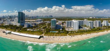 Güney Sahili 'nin kumlu yüzeyi. Sıcak Florida güneşinde dinlenen turistler. Güney Amerika 'da turizm altyapısı. Yüksek lüks otelleri ve apartmanları olan Miami Beach City..