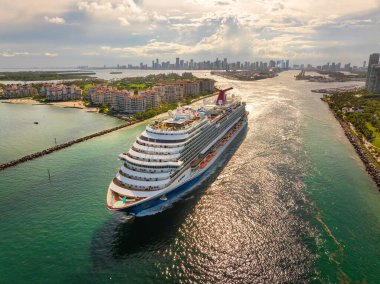 Liman kanalı boyunca seyahat eden lüks yolcu gemisiyle Miami, Florida 'nın hava manzarası. Otelleri ve daireleri olan liman manzaralı bir yer.
