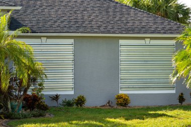 Fırtınaya dayanıklı çelik panjurlar, kasırgadan önce önlem olarak Florida 'daki evin camlarını kapatır. Ev aşırı havaya hazır..