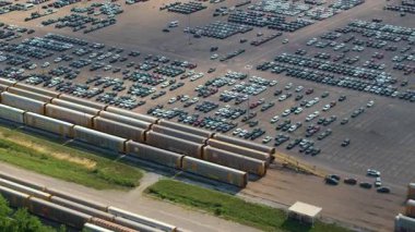 Kargo treni araba taşıyor. Satılık gıcır gıcır arabaları olan bir fabrika otoparkı. Amerikan otomotiv endüstrisinin gelişimi