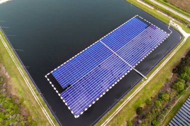 Yüzen fotovoltaik enerji santralinin üzerinden temiz elektrik enerjisi üretmek için birçok sıra güneş paneli görüntülenebilir. Su yüzeyinde hava kirliliği olmayan yenilenebilir elektrik kavramı.