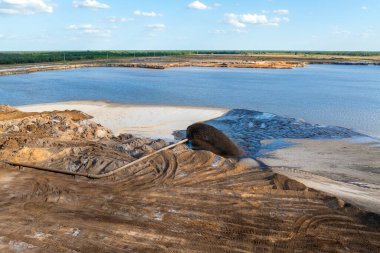 Florida 'nın merkezindeki açık fosfat çukurunda maden ekipmanları su ve kumu metal borulardan pompalıyor.