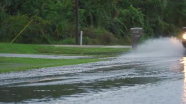 Florida 'da fırtına sonrası. Banliyö bölgesindeki derin sel sularında seyreden yavaş hareket eden araçlara sahip sulak yollar.