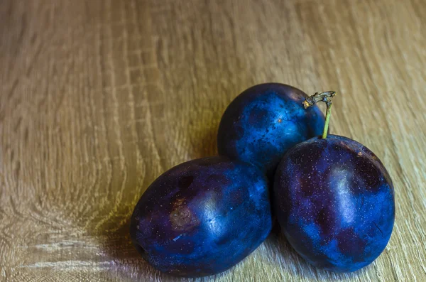 blue plums and wood background