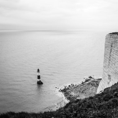 Akdeniz kıyısındaki bir deniz fenerinin siyah beyaz fotoğrafı.