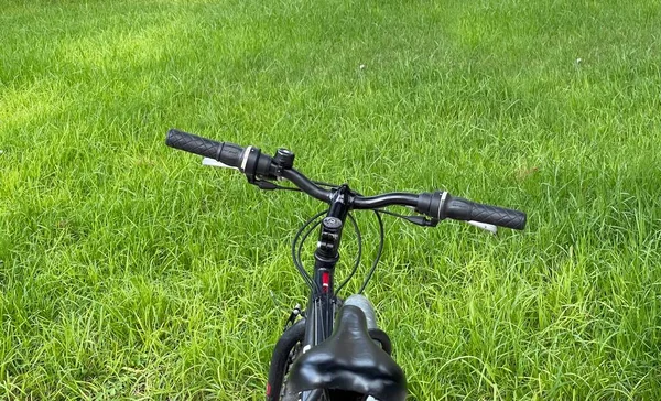 Bicicleta estacionada na grama verde — Fotografia de Stock