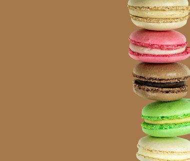Kahverengi çikolata arkaplan üzerine çok renkli Macaroon sütunu