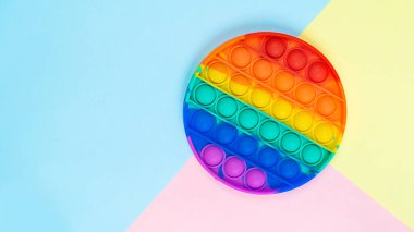 Renkli bir arkaplanda fotokopi alanı olan çok renkli gökkuşağı anti stres oyuncağı