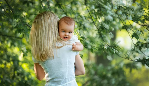 Bebé en brazos de las mamás, mirando a la cámara, detrás de las mamás — Foto de Stock