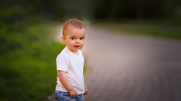 Retrato de un niño pequeño en jeans y una camiseta en la calle —  Fotos de Stock