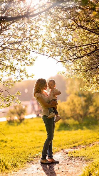 Silhouette di mamma e bambino all'ombra degli alberi Foto Stock