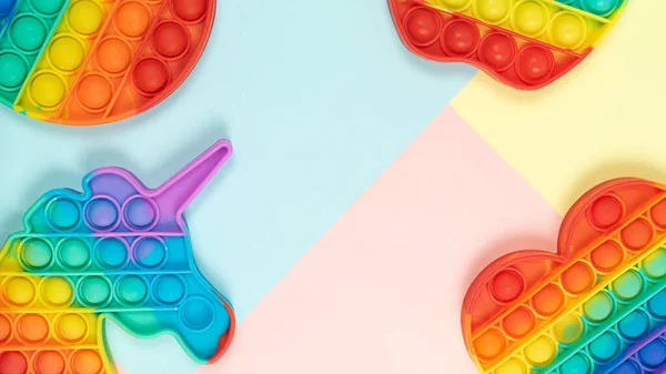Pop it toys on pastel colorful background flat lay top view with copy space