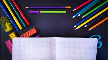 Okula dönüş kavramı, siyah karatahta okul malzemeleri açık defter, fotokopi alanı olan üst görünüm.