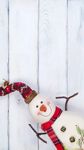 Christmas toy snowman on white wooden background with copy space, front view for postcards and gift bags