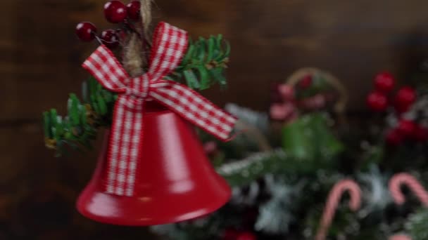 Weihnachtsglocken auf einem Holztisch neben einem Weihnachtsbaum, weihnachtlicher Winterhintergrund mit Kopierraum — Stockvideo