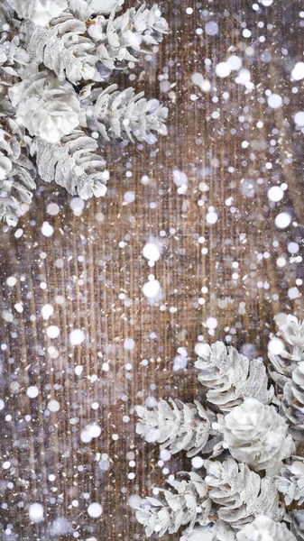 Kahverengi ahşap bir masada güzel beyaz koniler ve kar, fotokopi alanı olan Noel arkaplanı. — Stok fotoğraf