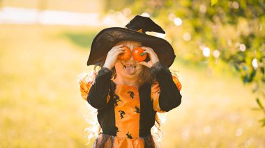 Küçük cadı kız Cadılar Bayramı 'nda iki küçük balkabağıyla eğlenir..