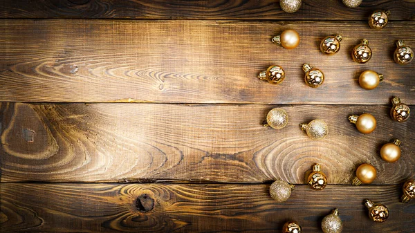 木製の茶色の背景に金色のクリスマスボール. — ストック写真