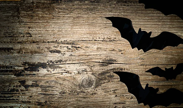 Grosses et petites chauves-souris noires sur un fond en bois avec espace de copie — Photo