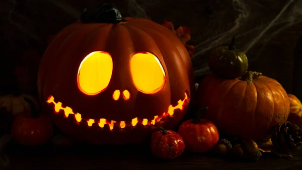 Κολοκύθες Jack-o-lantern close-up με λαμπερά μάτια και πορτοκαλί κολοκύθες φθινόπωρο, πολύ σκοτεινή νεκρή φύση, φόντο για το Halloween — Φωτογραφία Αρχείου