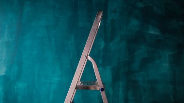 Yeni boyanmış bir duvarın arka planında bir merdiven.