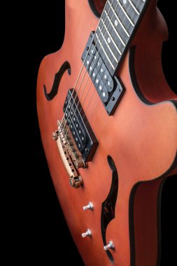 İçi boş gövde elektro gitar ile humbuckers. Makro çekim, siyah arka plan, karanlık anahtar
