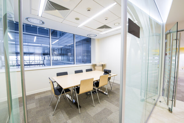 Empty small meeting room. Bright modern interior. Glass walls