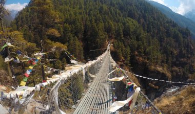 Suspension bridge walking between mountains clipart