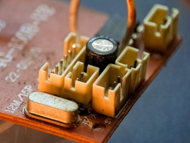 Kondansatör ve kuvars kristal osilatörlü elektronik devre kartı, karmaşık ayrıntıları gösterir.