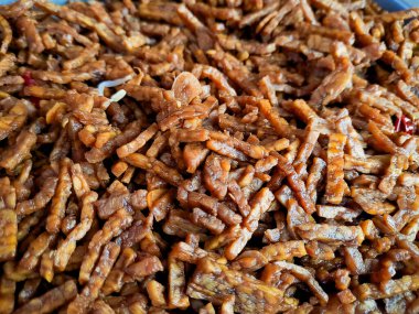 Bir yığın dilimlenmiş tempeh parçaları, iştah açıcı bir yemek için pişirilmiş ve baharatlı..