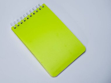 Canlı bir chartreuse not defteri köşegen olarak nötr arka plan, basit ve modern tasarım üzerine kuruludur..