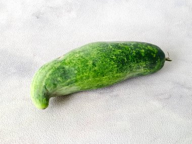 Canlı, kendine özgü kıvrımlı bir salatalık. Yemek fotoğrafçılığına ve sağlık odaklı içeriğe uygun..