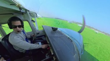 Güneşli bir günde takside çalışan ve hareket eden tek motorlu bir pilotun kokpit görüntüsü