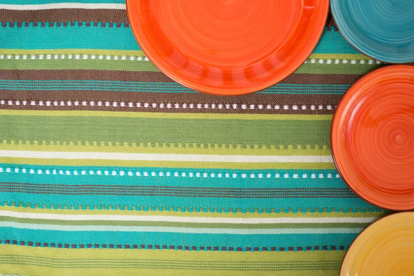 Farbige Teller auf dem gestreiften grünen Tuch — Stockfoto