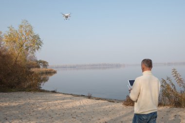 Adam kontrol uçan bir dron. Güneşli gün.