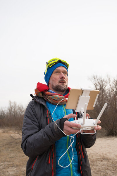 Bearded man carefully controls the flying drone