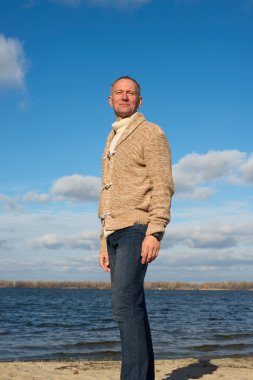 Gülümseyen adam, rahat giyen, sahil boyunca yürüyen , seyir