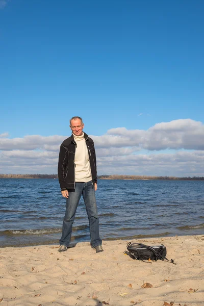 Hiker man standing on the beach, relaxing, smiling and having fu
