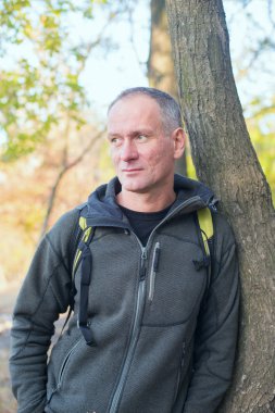 Etkin adam parkta rahatlatıcı sırt çantası ile.