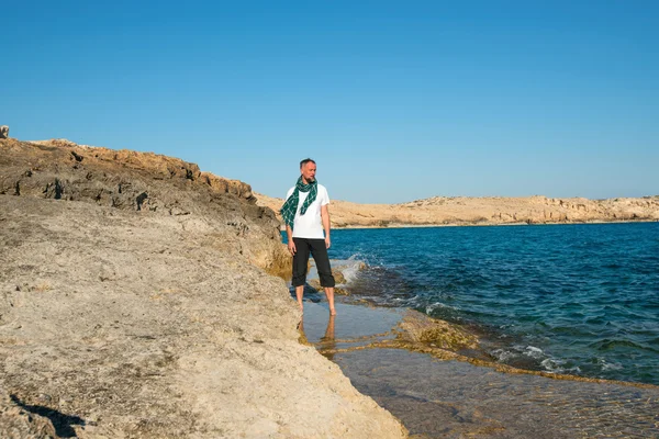 Brodaty mężczyzna stojący na skalisty brzeg — Zdjęcie stockowe